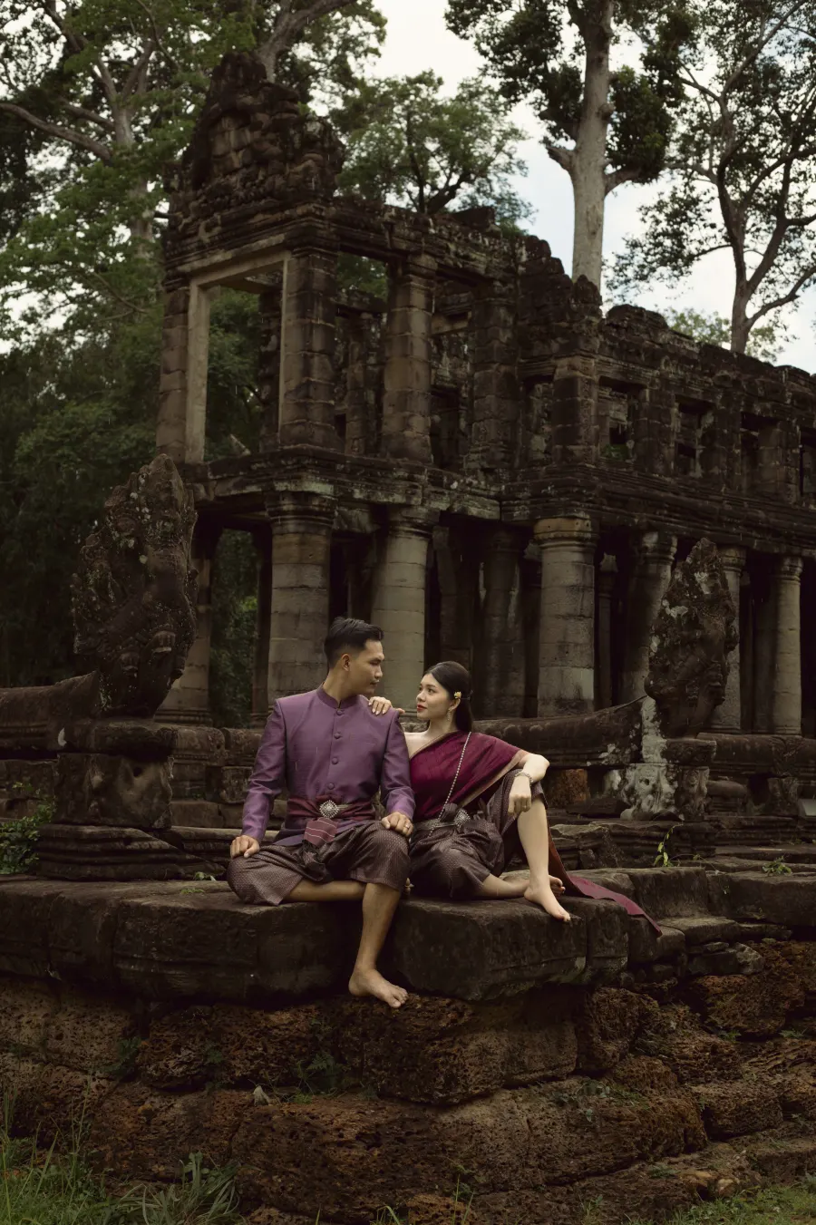 គូស្វាមីភរិយានៅប្រាសាទបុរាណ · The couple seated at an Angkor-era temple